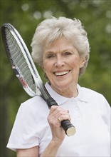 Portrait of senior woman with tennis racquet.