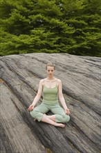 Woman practicing yoga in park.