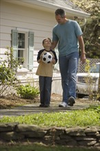Father and young son with soccer ball.