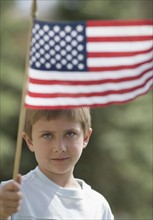 Young boy waving American flag.