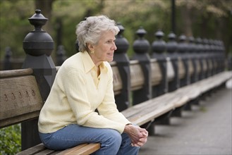 Portrait of woman sitting on park bench.