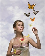 Young woman with flower and butterflies.