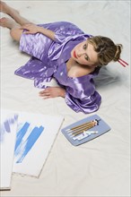 Woman in purple kimono with paint and brushes.