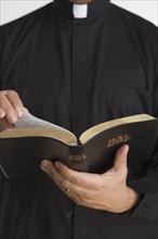 Close up of bible in priest’s hands.