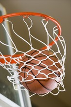 Close up of basketball in hoop.