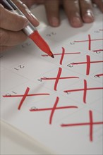 Close up of man crossing out days on calendar.