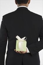 Man holding gift against his back.