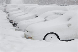 Cars buried in snow.