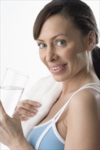 Woman holding glass of water after workout.