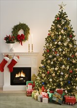 Christmas tree with presents and fireplace with stockings.