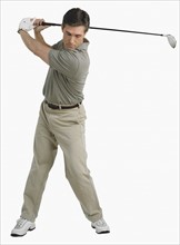 Studio shot of man playing golf.