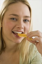 Portrait of woman eating a French fry.