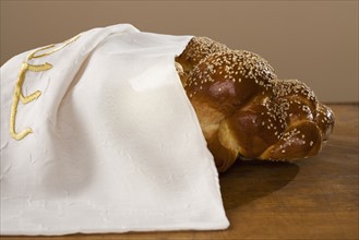 Loaf of Challah bread under cloth.