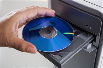 Close up of cd being inserted in to cd rom drive.