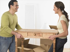 Couple moving a table.