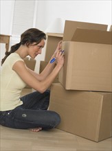 Woman marking boxes on moving day.