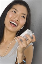 Young woman listening to an MP3 player.