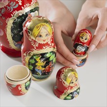 Close up of woman's hand with nesting dolls.