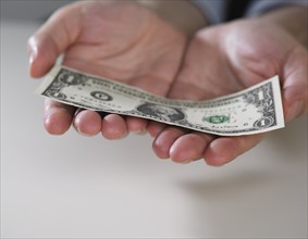 Hands holding an American dollar bill.