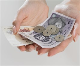 Close up studio shot of woman's hand holding money.