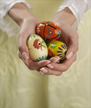 Close up of woman's hands holding painted eggs.