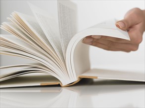 Close up of woman flipping pages in book.