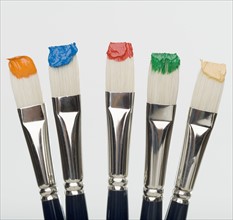 Close up of paint brushes with paint on bristles.