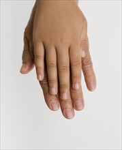 Close up of child's hand laying on adult's hand.