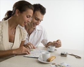 Couple looking at map and having coffee.