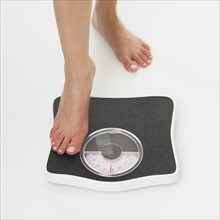Close up of woman stepping on scale.