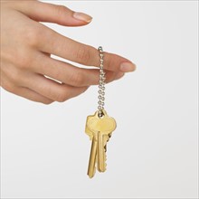 Studio shot of woman's hand holding keys.