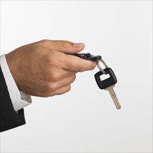 Close up studio shot of man holding car keys.