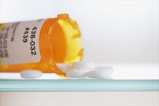 Close up of pills spilling out of medication bottle.