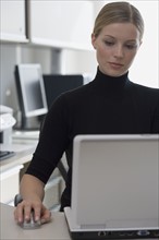 Businesswoman using wireless computer mouse.
