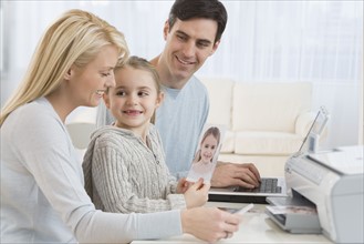 Family printing pictures with laptop.