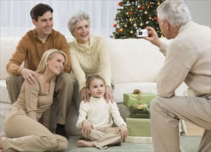 Grandfather taking photograph of family on Christmas.