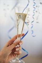 Close up of woman holding champagne flute.