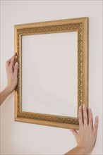 Woman hanging empty picture frame.