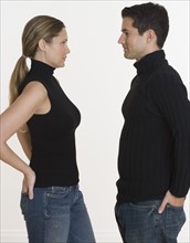 Studio shot of couple with hands in back pockets.