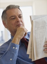 Senior businessman reading newspaper.