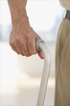 Close up of senior man holding cane.