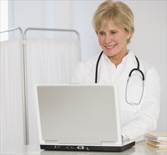 Senior female doctor looking at laptop.