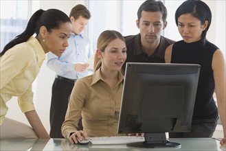 Group of businesspeople looking at computer.