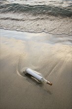 Message in bottle on beach.