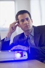 Businessman using projector in conference room.
