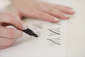 Close up of woman counting on paper.