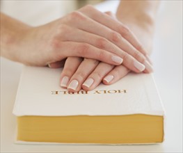 Woman's hands on Bible.