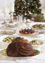Spiral ham and side dishes on Christmas table.