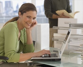 Portrait of businesswoman typing on laptop.