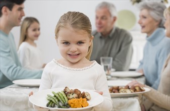 Portrait of girl holding plate at Thanksgiving.